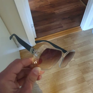 Solglasögon - Snygga solglasögon med en elegant detalj vid fästet. Perfekta för en stilren look. PRIS KAN DISKUTERAS