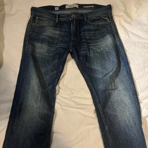 Blå jeansbyxor från Replay strl 33 - Snygga blå jeansbyxor från Replay med klassisk femficksdesign och knappgylf. De har en lätt tvättad look som ger en avslappnad stil. Perfekta för en casual outfit. Strl 33