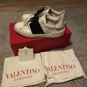 Valentino sneakers i vitt och svart - Säljer mina valentino open skorna är i fint skick storlek 43.   Det följer också med box och valentino skå påse. Skorna är självklart äkta 