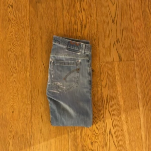 Dondup george jeans - Snygga blå dondup jeans med slitningar på framsidan. De är storlek 33/34 men passar 30/32