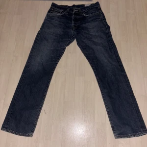 Mörkblå jeans från G-Star RAW - Säljer ett par mörkblå jeans från G-Star RAW. De har en klassisk femficksdesign med dragkedja och knappstängning. Jeansen har en rak passform och är tillverkade i slitstarkt denim. Perfekta för en avslappnad stil.