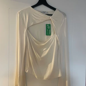 Krämvit långärmad topp från NA-KD - Säljer denna fina topp från NA-KD. Aldrig använd endast testat med prislapp kvar. Storlek L 