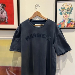 Maison Margiela oversized t-shirt  - Snygg blå t-shirt från Maison Margiela med texten 'MARGIELA' i en cool design på framsidan. Tillverkad i Italien med en klassisk rund halsringning. Perfekt för en stilren look. Retail: $725