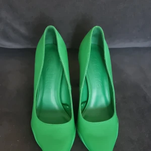 Gröna pumps med klack - Snygga gröna pumps BERSHKA med klack och spetsig tå. Perfekta för att lägga till en färgklick i din outfit. Tillverkade i syntetmaterial med en stilren design.