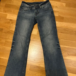 Blå jeans från H&M Divided - Snygga blå jeans från H&M Divided i storlek 34. Lågmidjade. Bootcut. Midjemått 33 cm rakt över. Innerbenslängd 78 cm. Det är dessa bilder jag har.