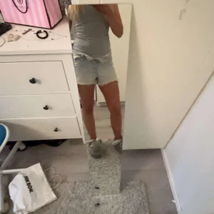 Ljusa jeansshorts från MNG - Snygga ljusa jeansshorts från Mango med fransiga kanter och slitna detaljer. Perfekta för en avslappnad sommarlook. De har en klassisk femficksdesign och knappar framtill. Använd fåtal gånger.