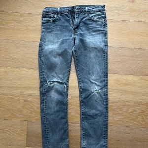 Levi’s jeans - grå - Levi’s jeans i grå färg Modell 504. Storlek 30/32 Väl använda med hål i knäna, ger en fräck look!