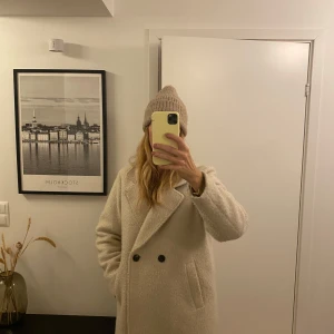 Beige kappa från Vero Moda - Säljer en superfin beige kappa från Vero Moda i mycket bra skick. Den har en klassisk design med dubbelknäppning och långa ärmar. Perfekt för höst och vinter, och den är både stilren och varm. Storlek L men passar även en M för en lite mer oversized look.