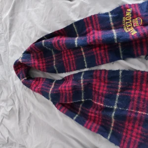 FC Barcelona halsduk - Säljer en supercool rutig halsduk från FC Barcelona. Den är i blått och rött med klubbens emblem broderat. Perfekt för att hålla sig varm på fotbollsmatcher eller bara som en snygg accessoar. Materialet känns mjukt och skönt, perfekt för kyliga dagar.