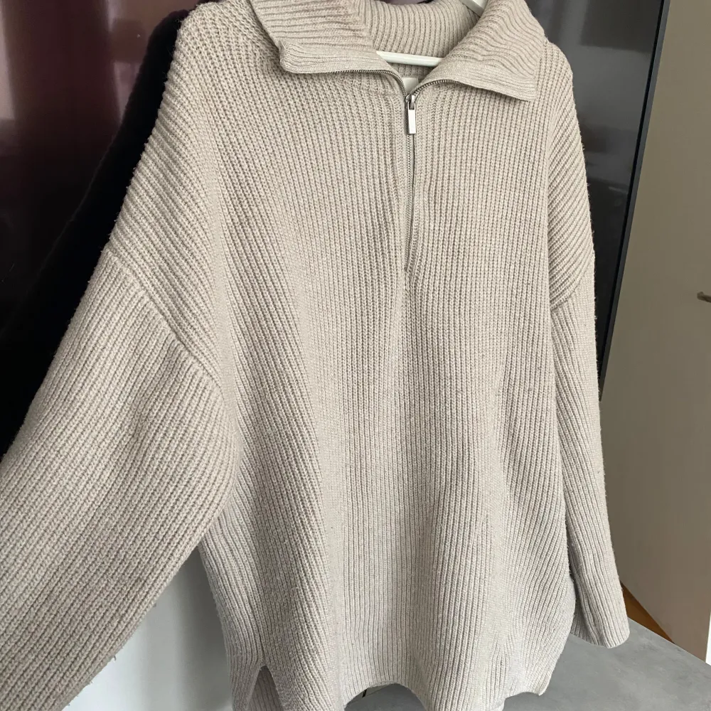 Beige stickad tröja med kort slits i sidan, från H&M. Tecken på användning, men fortfarande i bra skick. . Stickat.