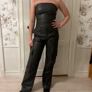 Skinndress  - Jättesnygg jumpsuit i skinn, prislappen är kvar och den är aldrig använd. Den är bekväm med stretchigt material.