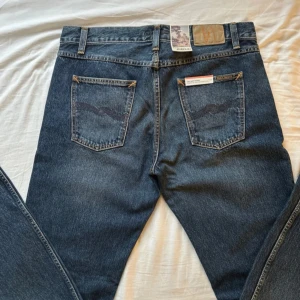 Nudie Jeans - Nudie Gritty jackson jeans i färgen Blue Soil Storlek 33/32 Aldrig använd, tags och kvitto medföljer Nypris 1200 danska kronor