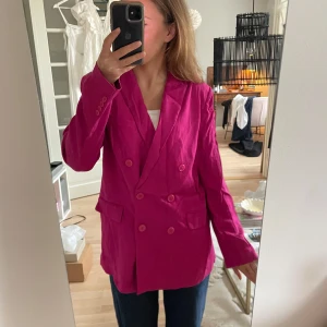 Rosa kavaj - Säljer en snygg rosa kavaj i storlek dam M. Den har en dubbelknäppt design med långa ärmar och en normal passform. Perfekt för både vardag och fest!