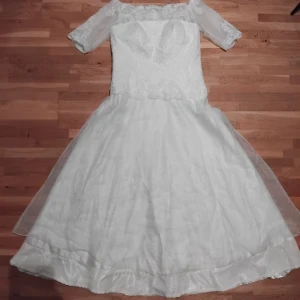 Vit brudklänning med spetsdetaljer - Välsydd brudklänning med vackra spetsdetaljer och trekvartsärmar. Klänningen har en offshoulder-design som ger en romantisk känsla. Perfekt för bröllop eller andra speciella tillfällen. Den är i mycket bra skick och redo att bäras. Klänningen är förlängd nertill av skräddare men kan tas bort om man inte behöver längden. Mer exakta mått kan jag komplettera med. Använd en gång, tvättad efter. 