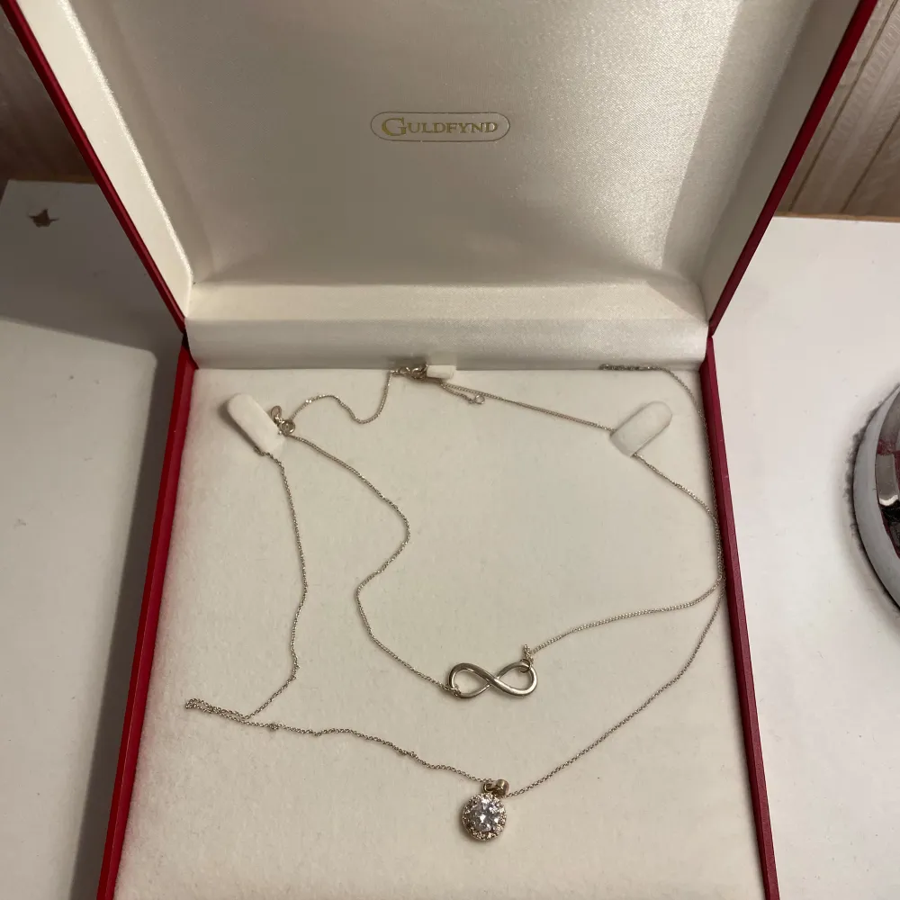 Säljer ett elegant smyckeset från Guldfynd med två halsband. Det ena har ett oändlighetstecken och det andra en gnistrande rund berlock. Perfekt för att ge en touch av stil till vilken outfit som helst. Kommer i originalförpackning. Priset går alltid att diskuteras🤩. Asusteet.