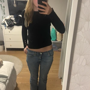 Svart långärmad tröja - Säljer en stilren svart långärmad tröja i bra skick. Perfekt för höst och vinter, med en tight passform som sitter snyggt. Tröjan är enkel men kan stylas upp med accessoarer för en mer festlig look. Passar både till vardags och lite finare tillfällen.