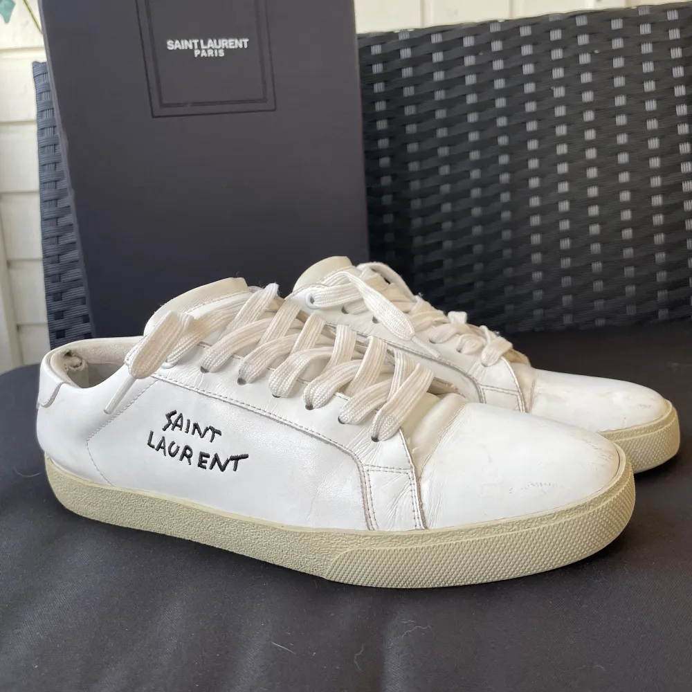 Säljer ett par stilrena vita sneakers från Saint Laurent. Skorna är i bra skick med lite märken framtill. Men fortfarande superfräscha! Kommer med originalkartong. Skick 8/10.  Pris kan diskuteras.. Skor.