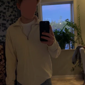 Beige tröja med dragkedja från East West - Säljer en beige tröja från East West i storlek m. Den har en dragkedja framtill och en liten bröstficka. Perfekt för en avslappnad stil och passar bra till jeans. Tröjan är i bra skick och använd fåtal gånger 