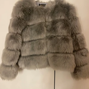 Grå pälsjacka från Lanshifei - Säljer en supermjuk och fluffig grå pälsjacka från Lanshifei. Perfekt för att hålla sig varm och stilren under kyliga dagar. Jackan har är liten i passform (xxl men passar m perfekt) och men med långa ärmar, vilket gör den idealisk för både höst och vinter. Ett måste för garderoben om du älskar att vara både bekväm och trendig🩶