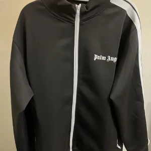 Svart track jacket från Palm Angels - Säljer en snygg svart track jacket från Palm Angels med vita ränder längs ärmarna. Passar både höst och vår. Priset kan diskuteras vid snabb affär. 