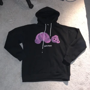 Palm angels hoodie - Säljer en svart hoodie från Palm angels med ett lila tryck på framsidan💜🖤 Tröjan är i gott skick då den har använts sparsamt. Vid frågor och funderingar så kom privat. Även om du vill ha mer bilder🔛🔝✅