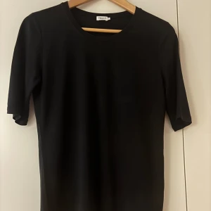 Svart t-shirt från Filippa K - Säljer en stilren svart t-shirt från Filippa K i mycket bra skick. Den är kortärmad och gjord av mjukt material, perfekt för både vardag och fest. Passar till allt och är ett måste i garderoben! 🖤