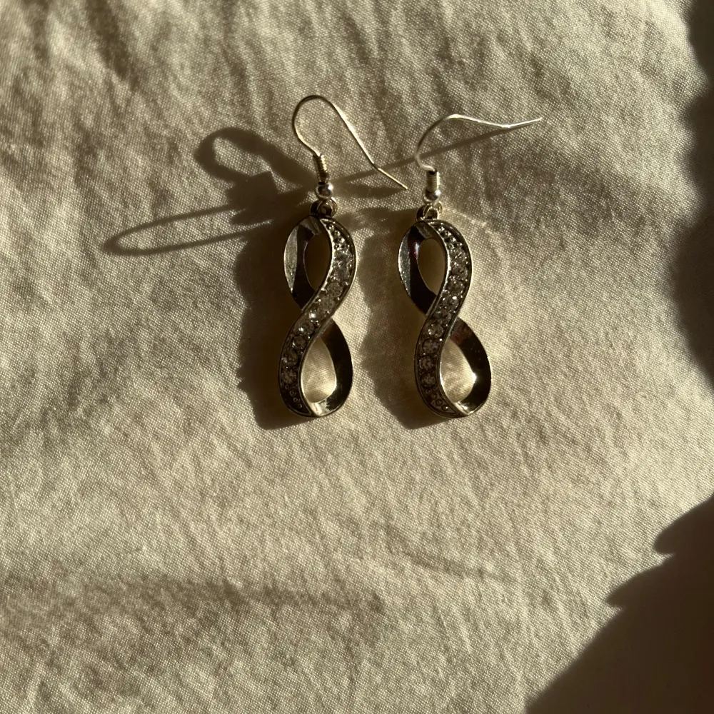 Säljer tre par snygga örhängen i silverfärg. 35kr/styck Ett par med rosdesign och detaljerade blad, ett par med en elegant twistad form (som evighetstecknet) med glittriga stenar, och ett par klassiska creoler med en glittrig yta. Perfekta för att piffa upp vilken outfit som helst! 🌟. Asusteet.