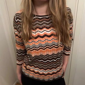 Stickad topp med missoni mönster - Säljer en superfin tröja med vågigt mönster i brunt, orange och vitt. Tröjan är stickad och har trekvartsärmar, sitter fint på mig som brukar ha S/M. 🧡🤎