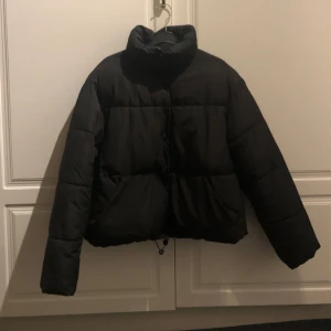 Svart pufferjacka från Zara - Säljer en svart pufferjacka från Zara i storlek S. Jackan är perfekt för kalla dagar med sin tjocka vaddering och höga krage. Den har en dragkedja och knappar framtill för extra skydd mot kylan. 🖤