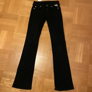 Svarta lågmidjade bootcut jeans från Replay - Säljer ett par snygga svarta low waist bootcut jeans från Replay i storlek 24/34. Jeansen är helt nya med prislappen på. Köpta för 700kr.             Midjemått: 33cm, innerbendlängd 82cm.            Kan sälja för 350kr vid en snabb affär.❤️💕