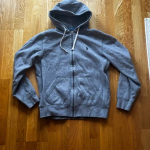 Mörkgrå Zip Hoodie Ralph Lauren - Säljer en snygg mörkgrå hoodie från Ralph Lauren. Bra skick men liten i storlek så denna passar nån som i vanliga fall har S