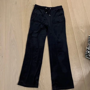 Mörkblåa byxor från Juicy Couture - Säljer ett par mörkblåa byxor från Juicy Couture i mjukt material. De har en loose passform med snörning i midjan och fickor både fram och bak. Använda fåtal gånger och inga defekter.