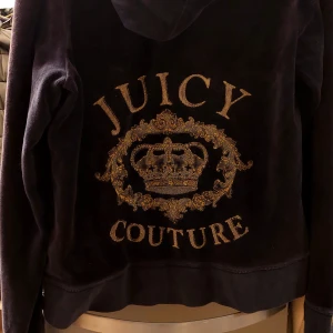 Mörkblå hoodie från Juicy Couture - Säljer en snygg mörkblå hoodie från Juicy Couture i mjukt material. Dragkedje berlocken och loggan bak är guldiga. Perfekt för en avslappnad och stilren look. Passar både till vardags och festliga tillfällen!  Storleken enligt lappen är XL men jag tror den är mer M? (Sitter nog taht o snyggt på L/XL och lite oversized på S) Skriv för fler bilder och priset kan alltid diskuteras!