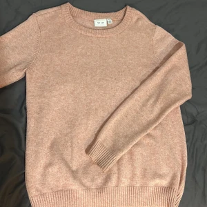 Rosa stickad tröja från Vila - Mysig beige stickad tröja från Vila i mycket bra skick. Perfekt för höst och vinter med långa ärmar och ribbade muddar. Superfin att ha till jeans eller kjol för en avslappnad look. 🧡