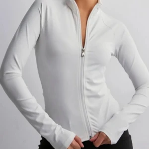 Vit långärmad träningströja med dragkedja - Säljer en stilren vit långärmad tröja med dragkedja framtill. Tröjan har en tight passform som framhäver figuren och är gjord i ett mjukt och bekvämt material. Använd fåtal gånger så bra skick . Säljer pga den är lite för tajt för mig över bysten. 🩷