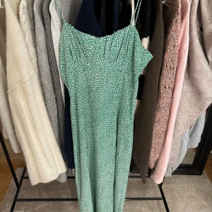 Långklänning Zara  - Endast använd 1 gång. En längre grön/vit klänning från Zara. Snörning och lite öppen i ryggen. Har även knappar på sidan fram samt en slits. Passar mig som är 164 och vanligtvis bär S/M☺️☺️