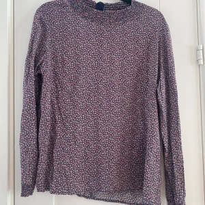 Blommig blus i viskos i strl 42 från Minus redefining Scandinavia - Blommig blus i viskos i strl 42 från Minus redefining Scandinavia.  Endast använd vid ett par tillfällen och är i väldigt fint begagnat skick.  Mått Över bröstet: ca 55 cm Längd från axeln: ca 63 cm 100% viskos  Kommer från ett djur/rökfritt hem