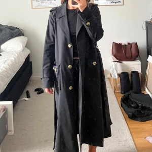 Svart Trenchcoat  - Super fin trenchcoat från Twist&Tango i kavaj material. Knappt använd så den är verkligen i toppskick. Säljs inte länge men finns en likande i beige för referens till priset.