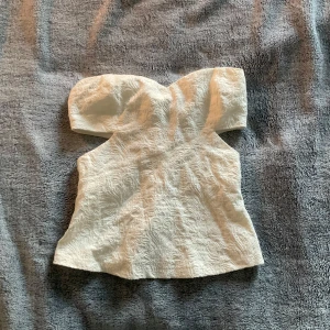 Tubtopp  - Säljer fin tubtopp från zara i bra skick. Toppen har dragkedja baktill och mönstrat tyg. Toppen har fina öppningar på sidan.