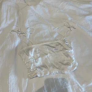 Zara topp - Säljer denna fina croppade satin topp som man knyter med rosetter från Zara då den inte kommer till användning! Använd en gång och är i väldigt bra skick!!🙏🏼 perfekt till middagar eller fest🤍 skönt material och har inga defekter