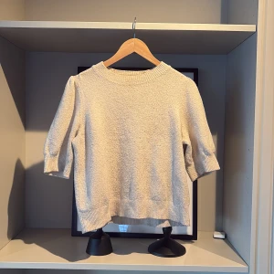 Beige tröja från Vero Moda - Säljer en stilren beige tröja från Vero Moda. Tröjan har trekvartsärmar och är stickad. Har en liten mörkare fläck bak på halsringningen (bild 3) men inget som syns vid användning. Den är inte använd mycket men är något nopprig (bild 4). Nypris 230kr