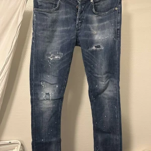 Blå jeans från Dondup - Säljer ett par blå jeans från Dondup med slitna detaljer och en cool tvätt. Jeansen är i strl 31 och är av modellen George. Dem är i bra skick. 