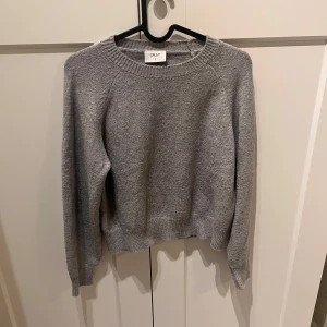 Grå stickad tröja från Grunt - Säljer en stilren grå stickad tröja från Grunt. Tröjan har en rund hals och långa ärmar. Den är i gott skick. Storlek S men motsvarar ungefär storlek 152 