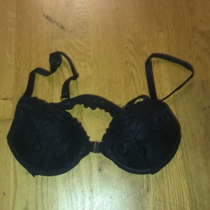 Svart spets-bh - Snygg svart bh med spetsdetaljer. Tillverkad i 90% polyamid och 10% elastan för en bekväm passform. Perfekt för att ge en elegant touch till din outfit. Säljer då den var för liten. Använt en gång.