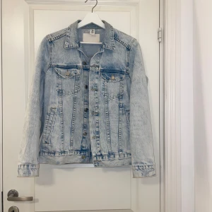 Ljusblå jeansjacka från H&m - Säljer en klassisk ljusblå jeansjacka från H&M. Jackan har långa ärmar, knappar framtill och två bröstfickor med knappstängning. Perfekt för en avslappnad stil. Har nästan aldrig haft på mig den! Pris går att diskutera!!