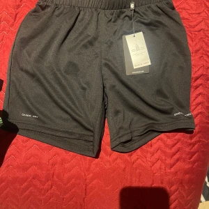 Svarta träningsshorts med Quick Dry - Snygga svarta träningsshorts med Quick Dry-teknologi. Perfekta för intensiva träningspass. Elastisk midja för bekväm passform.