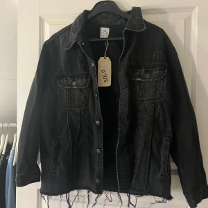 Jeansjacka - Cool svart jeansjacka med slitna detaljer och tryck på baksidan'. Jackan är från eget UF företag så trycket är eget. Storlek S/M. Aldrig använd. Bra skick. Säljer för 199kr + frakt eller lägg ett prisförslag😍