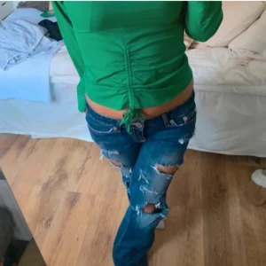 Blå jeans med slitningar - Säljer ett par blå jeans med coola slitningar. Perfekta för en avslappnad look. De har en klassisk femficksdesign och en bekväm passform.