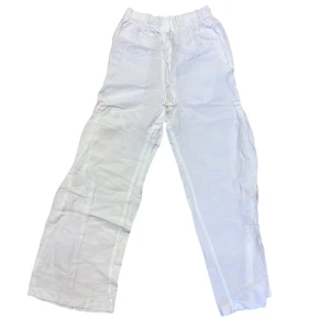Vita linnebyxor - Säljer ett par vita linnebyxor med elastisk midja. Byxorna har en loose passform och är perfekta för varma dagar. De är enkla och stilrena, vilket gör dem lätta att matcha med olika toppar.