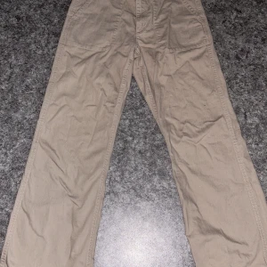 Beige cargopants från Åhlens - Snygga beige cargopants från Åhlens. Perfekta för en avslappnad stil. Byxorna har en loose passform och är tillverkade i bomull för extra komfort. Dom är inte använda så mycket så är i bra skick.